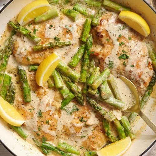 Overhead view of creamy asparagus chicken in a skillet.