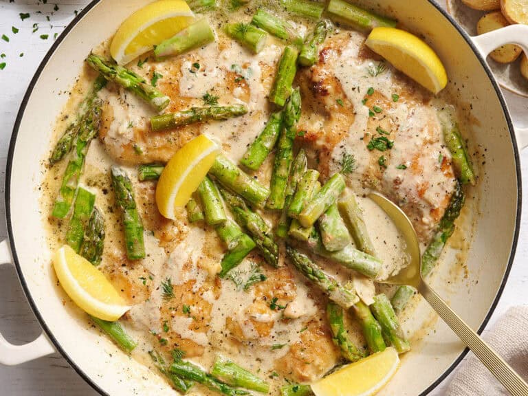 Overhead view of creamy asparagus chicken in a skillet.