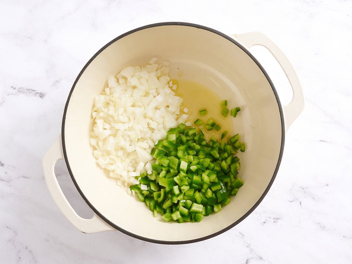Diced onion, diced green bell pepper and oil in a pot.