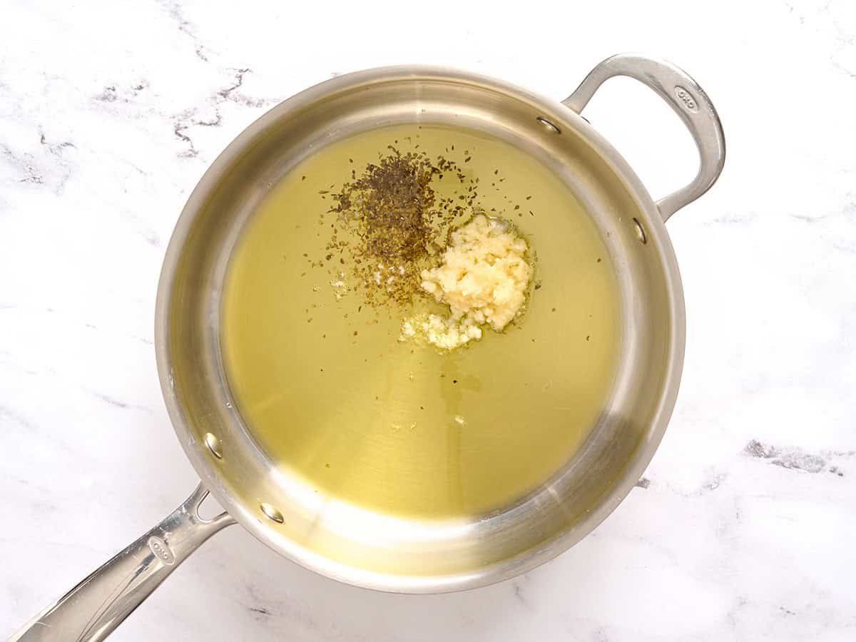 Garlic, herbs and oil in a skillet.