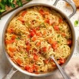 Overhead view of a pot of angel hair pasta pomodoro with a fork.