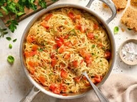 Overhead view of a pot of angel hair pasta pomodoro with a fork.