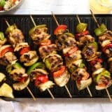 Overhead view of chicken kabobs on a grill.
