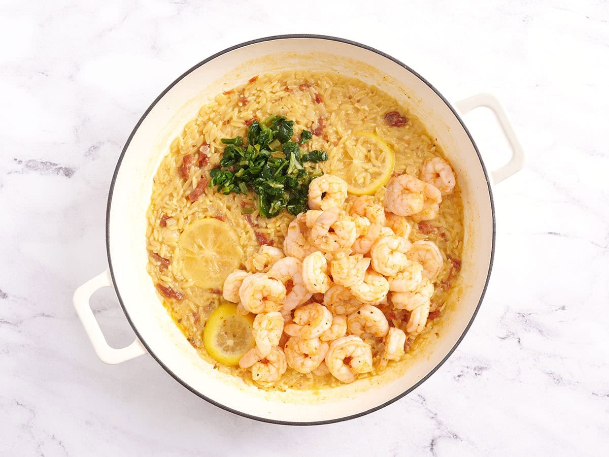 Shrimp and parsley in a skillet with orzo.