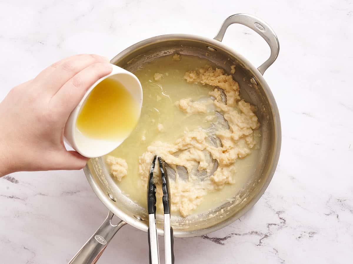 Broth being added to the skillet for poppy seed casserole sauce.