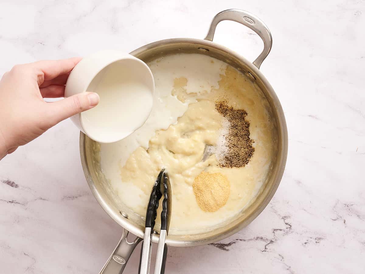 Milk and seasoning in a skillet.