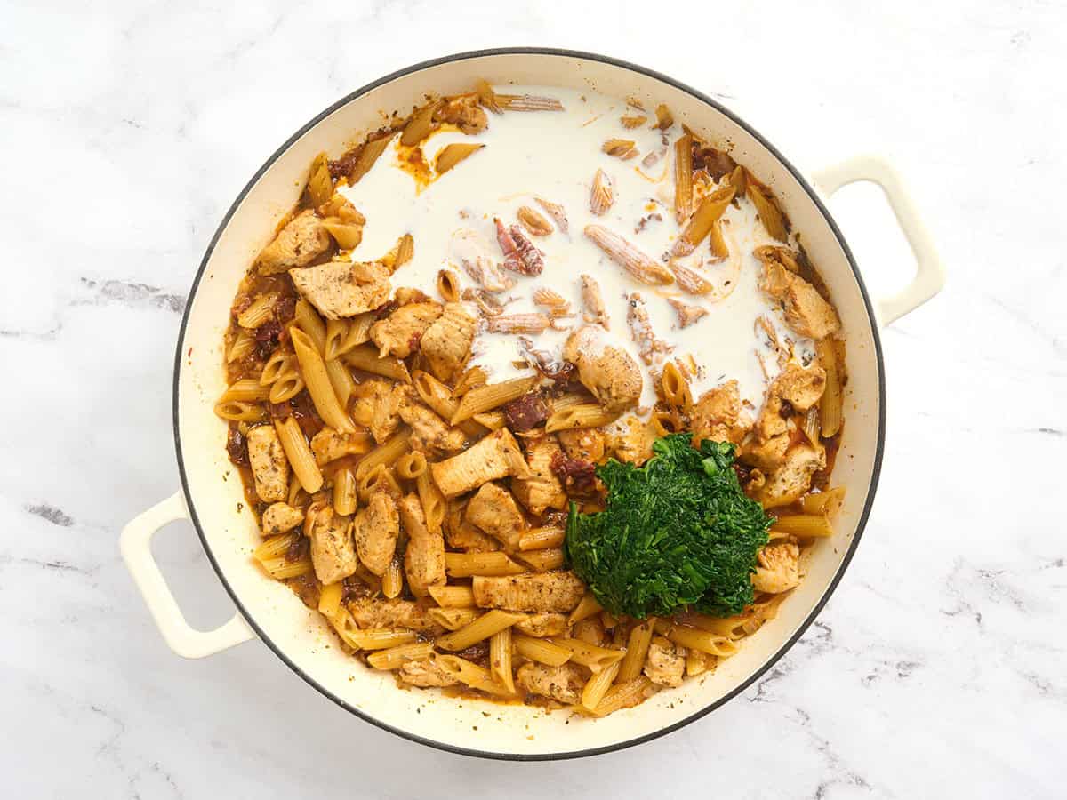 Heavy cream and thawed spinach added to marry me chicken pasta.