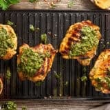 Overhead view of chimichurri grilled chicken on a grill.