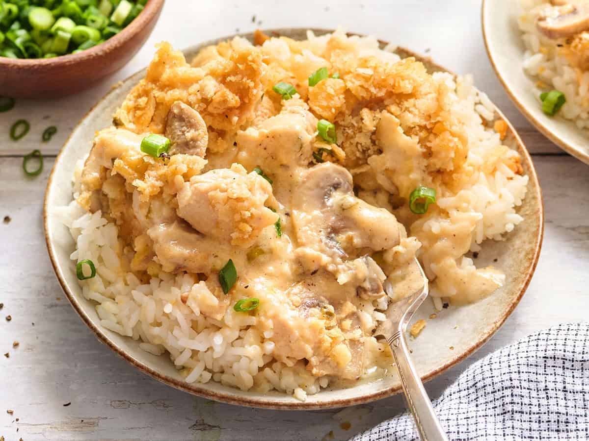 Side view of a million dollar chicken casserole on a plaet with rice.