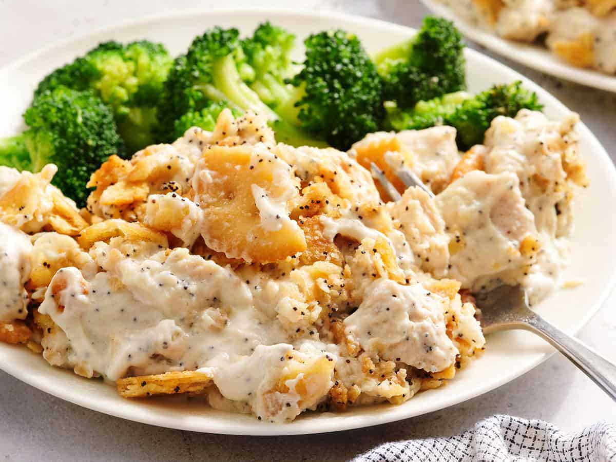 Side view of poppy seed casserole on a plate with broccoli.
