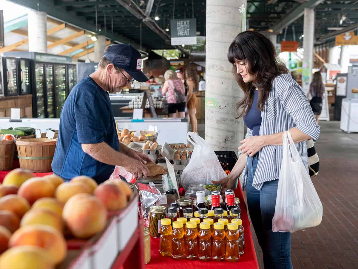 woman buying produce from a man at farmers market