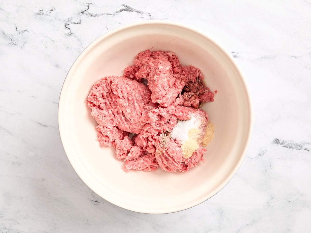 Ground beef and seasonings in a bowl.