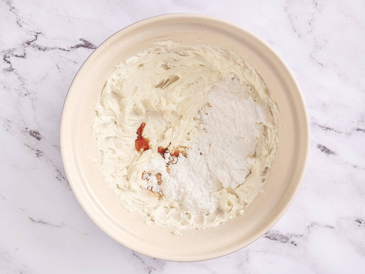 Cream cheese, vanilla and powdered sugar in a bowl.