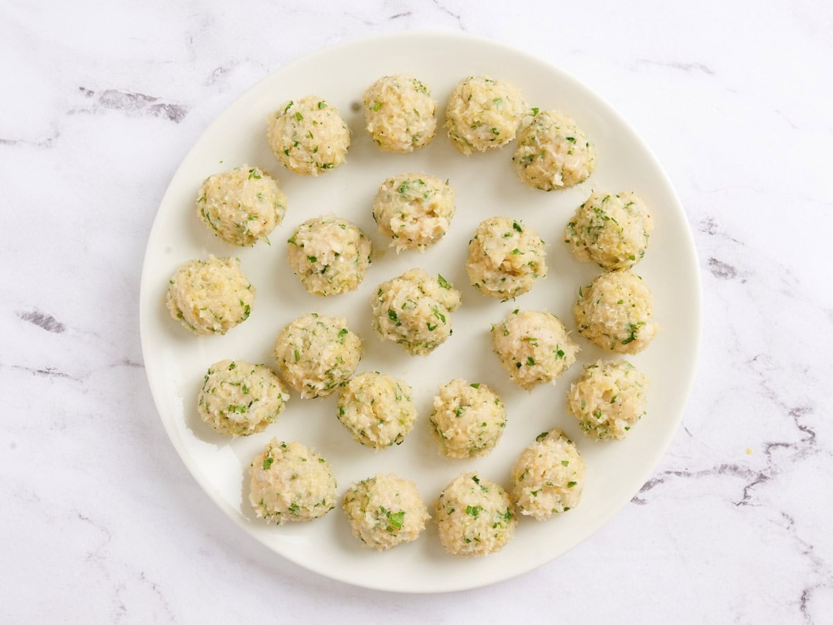 Chicken piccata meatballs before cooking on a plate.