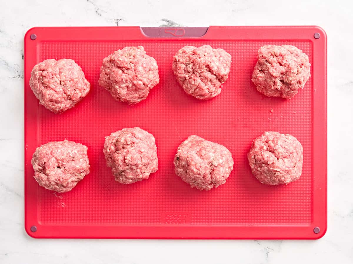 Ground beef formed into balls on a cutting board.
