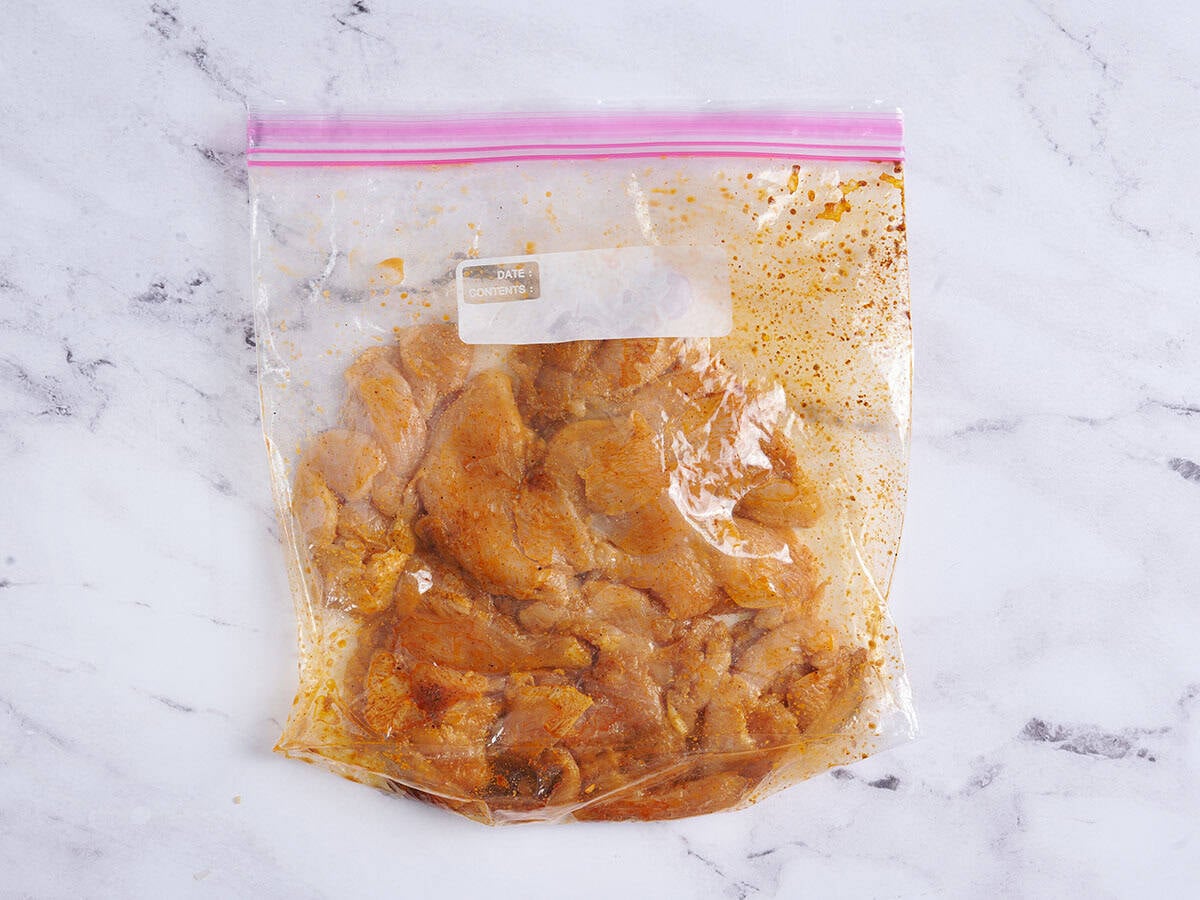 Chicken marinating in a zip-top bag.