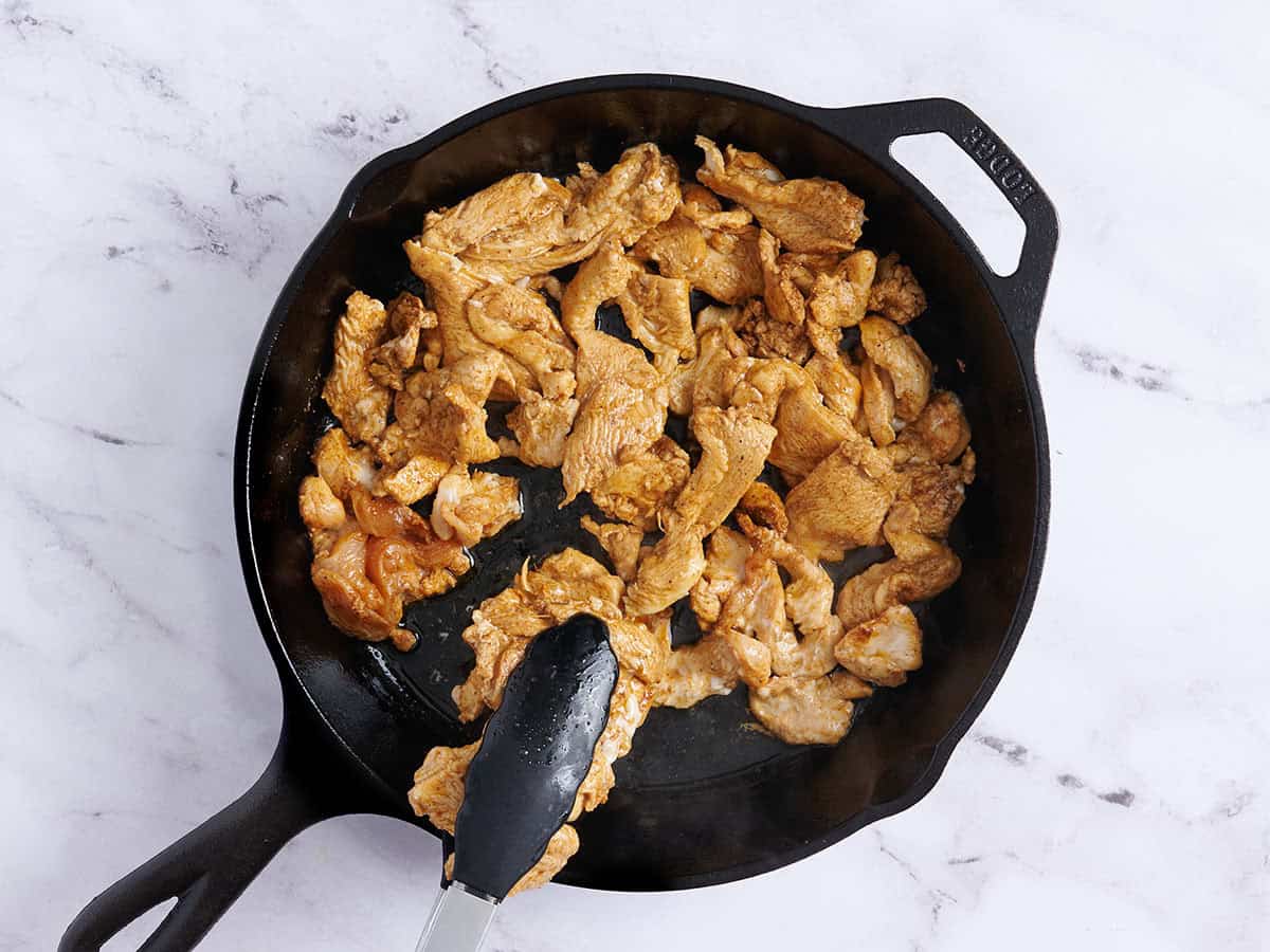 Chicken searing in a skillet.