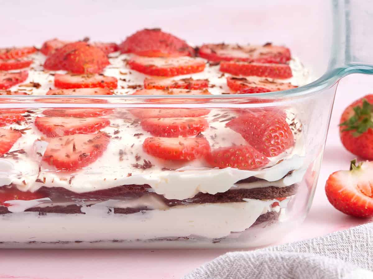 Side view of chocolate strawberry icebox cake in glass baking dish.