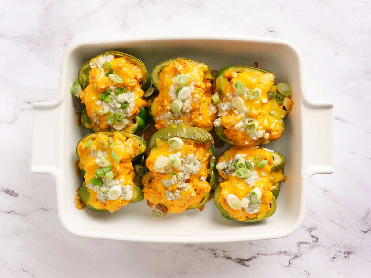 Buffalo chicken stuffed peppers in a baking dish.