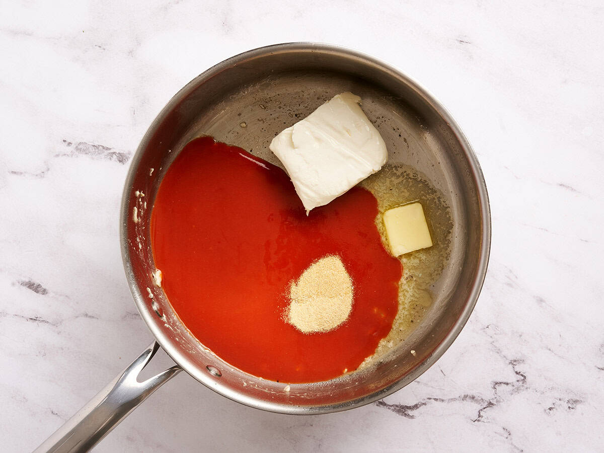 Hot sauce, cream cheese, butter and seasonings in a pan.