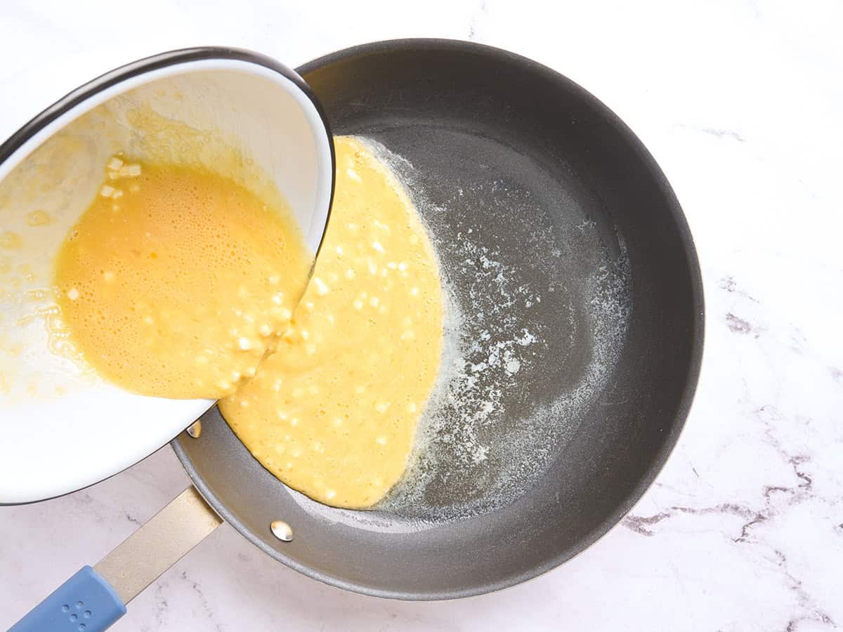 Cottage cheese egg mixture being poured into a skillet.