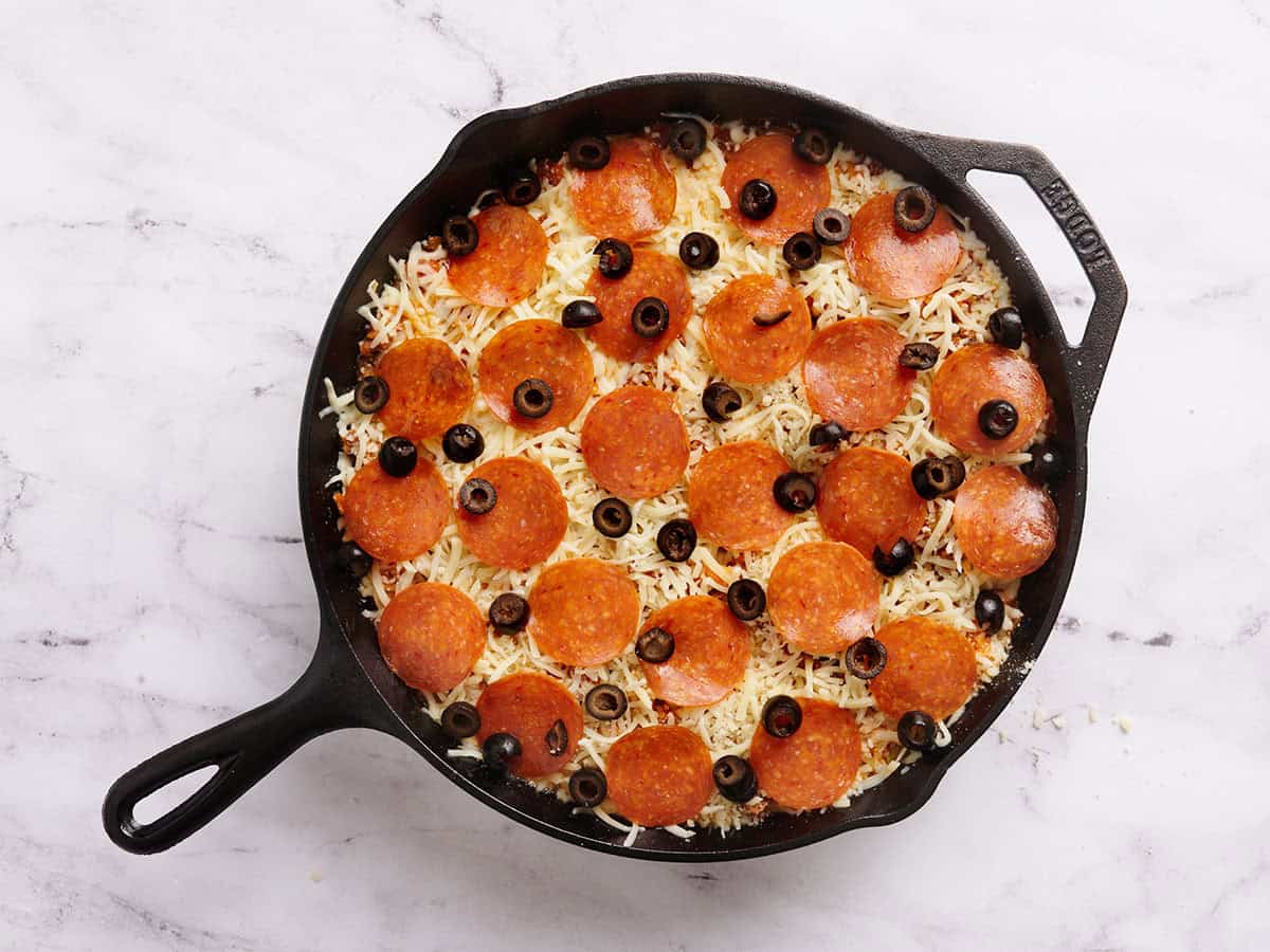 Pepperoni and olives added to a skillet pizza casserole.