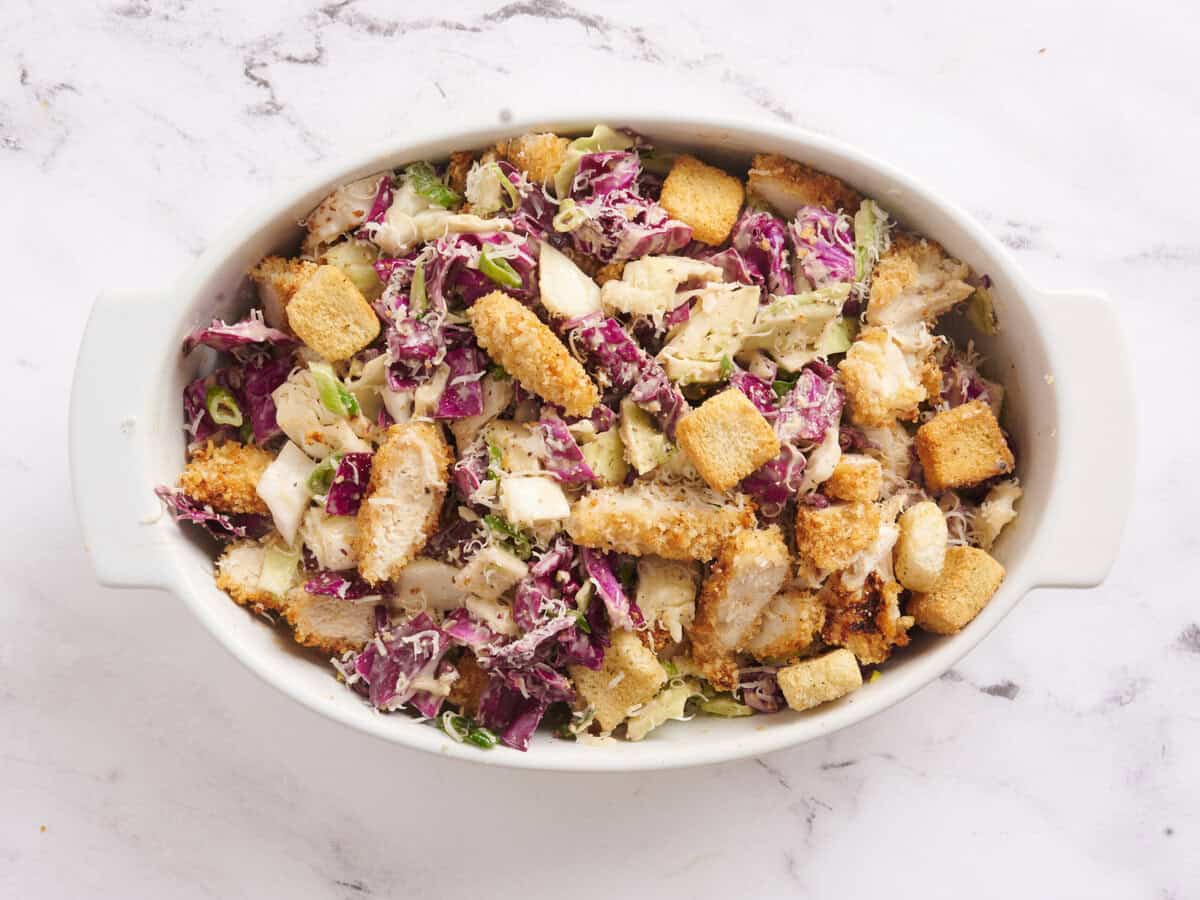 Caesar slaw with crispy chicken in a baking dish.