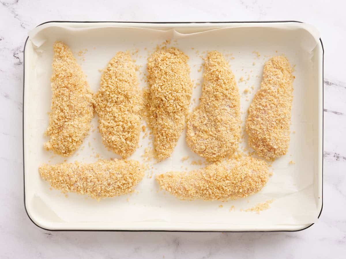 Chicken tenders on a baking sheet before baking.