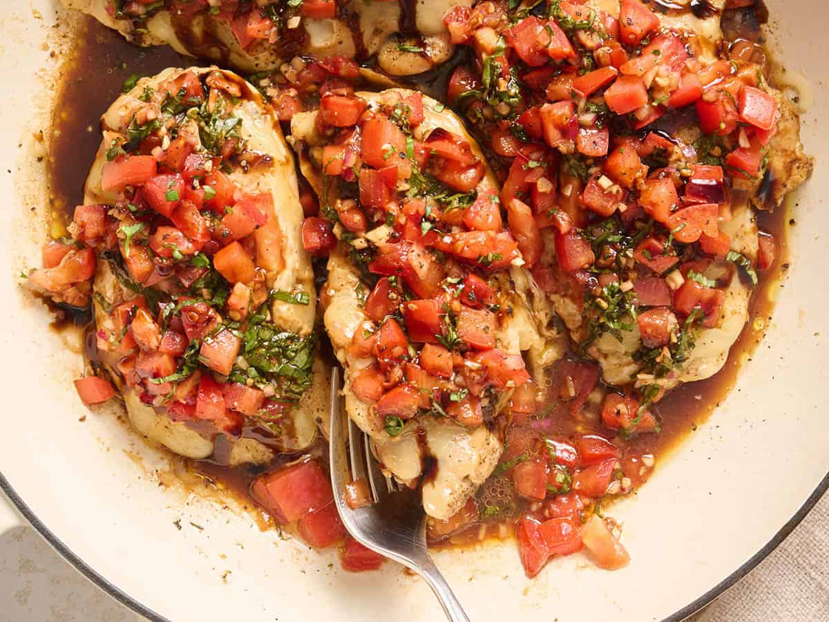 Overhead view of bruschetta chicken in a skillet.