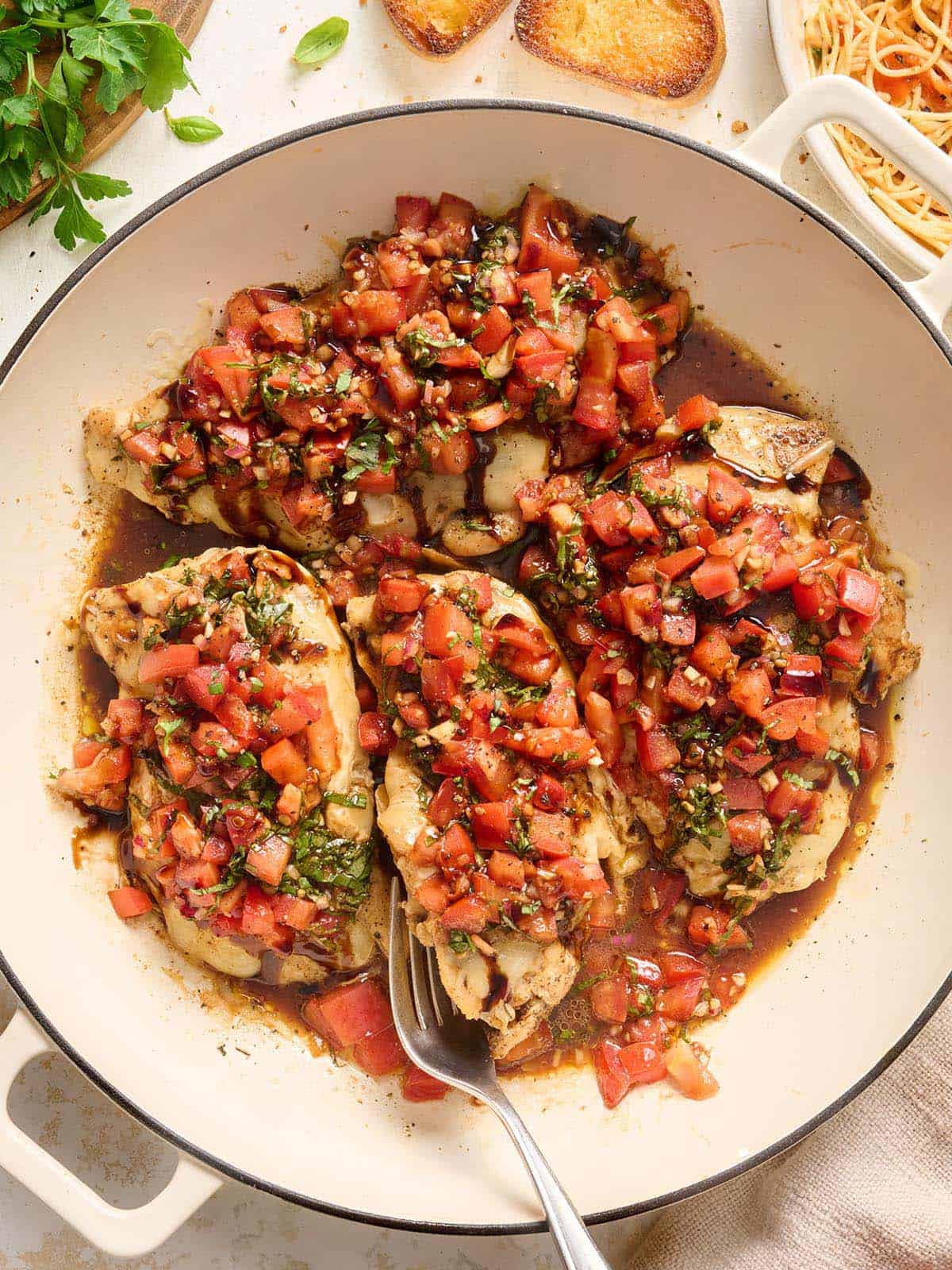 Overhead view of bruschetta chicken in a skillet.
