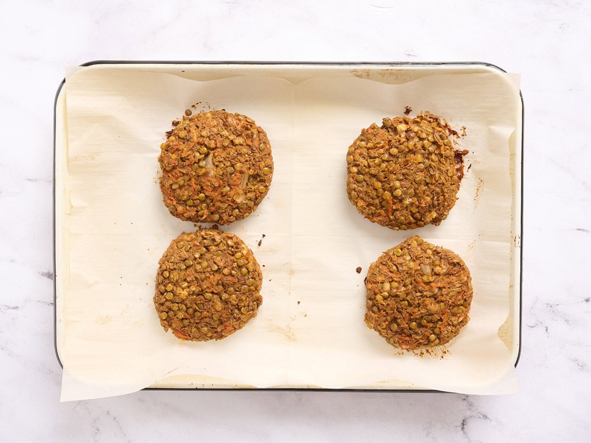 Freshly baked homemade lentil burgers on a sheet pan.