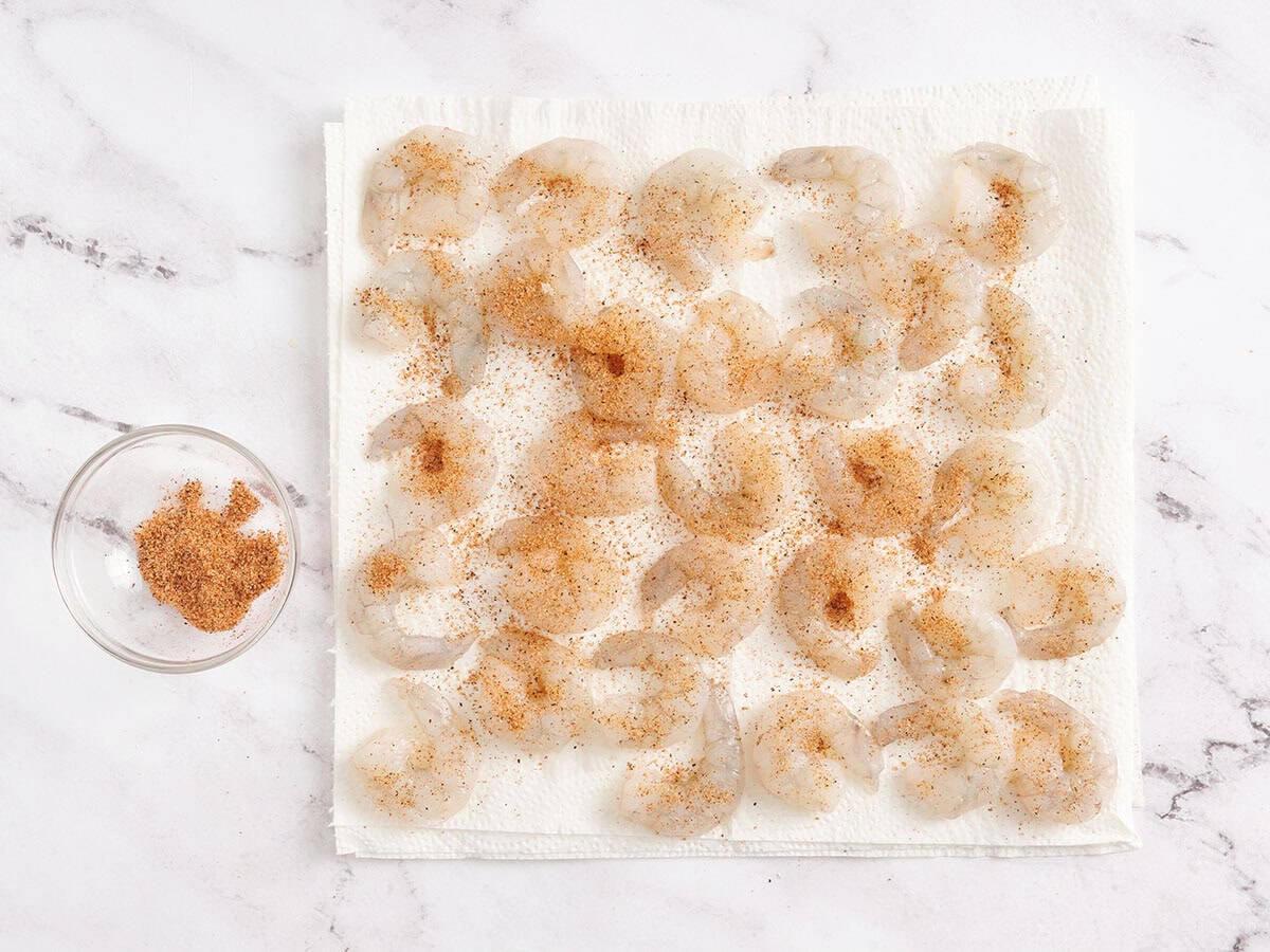 Shrimp on a paper towel with cajun seasoning.