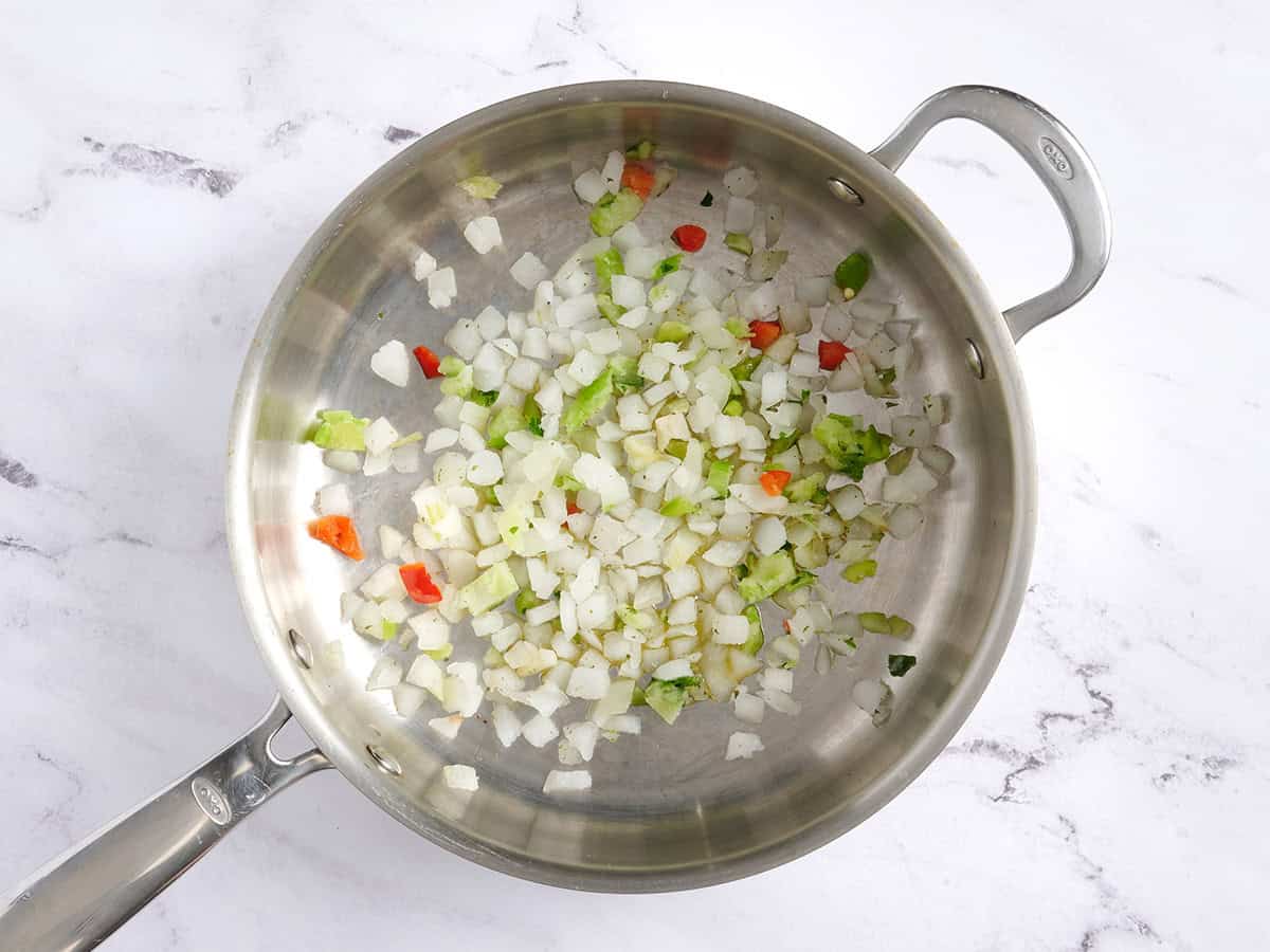 Diced frozen peppers and onions in a skillet.