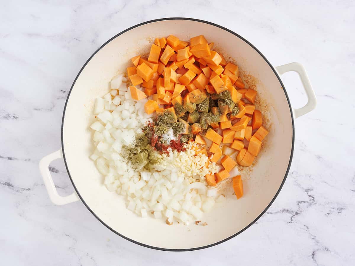 Diced sweet potatoes, onions and seasonings in a skillet.
