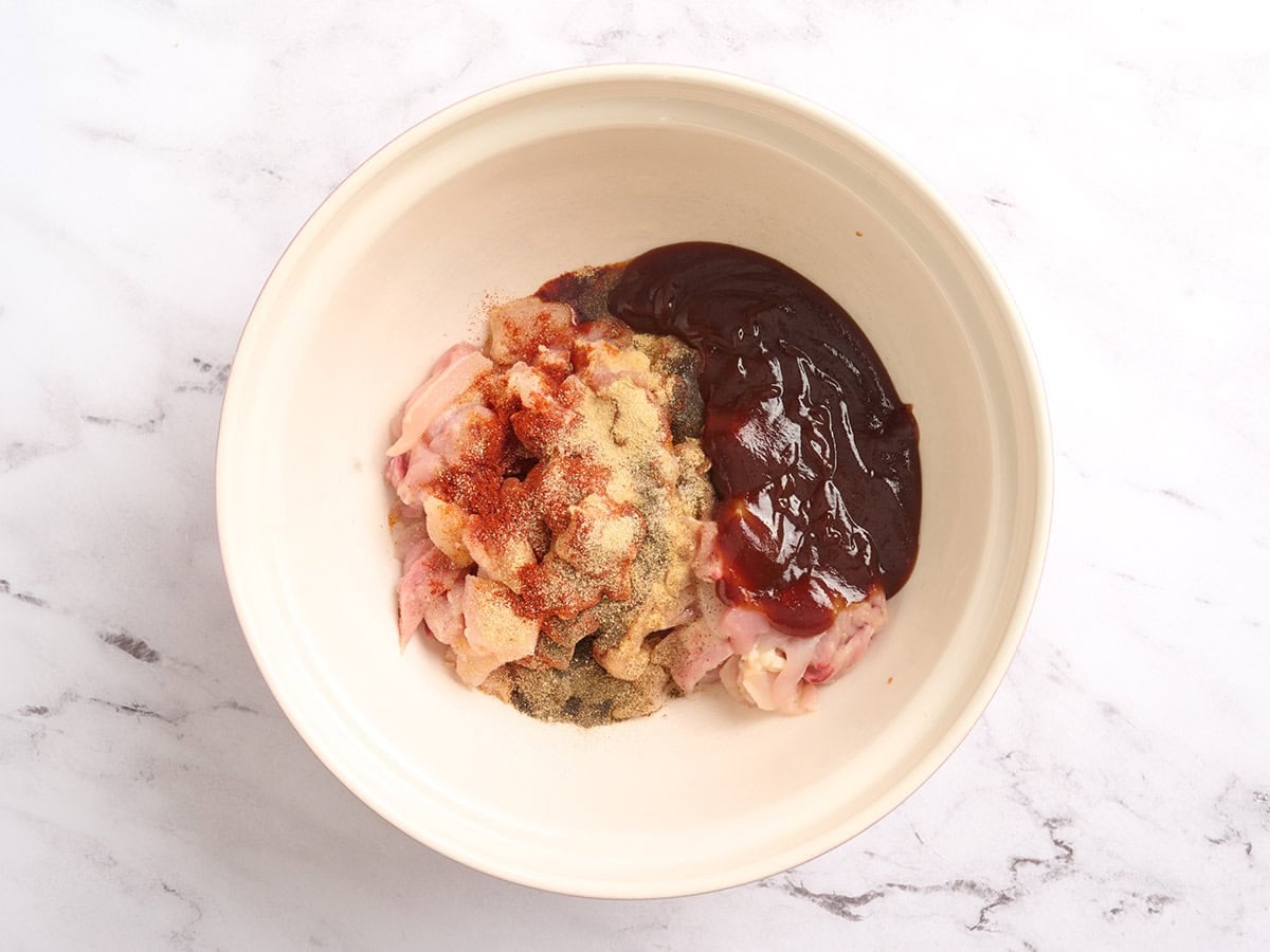 Diced chicken, seasonings and BBQ sauce in a bowl.
