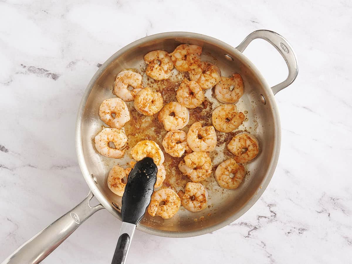 Shrimp being seared in a skillet.
