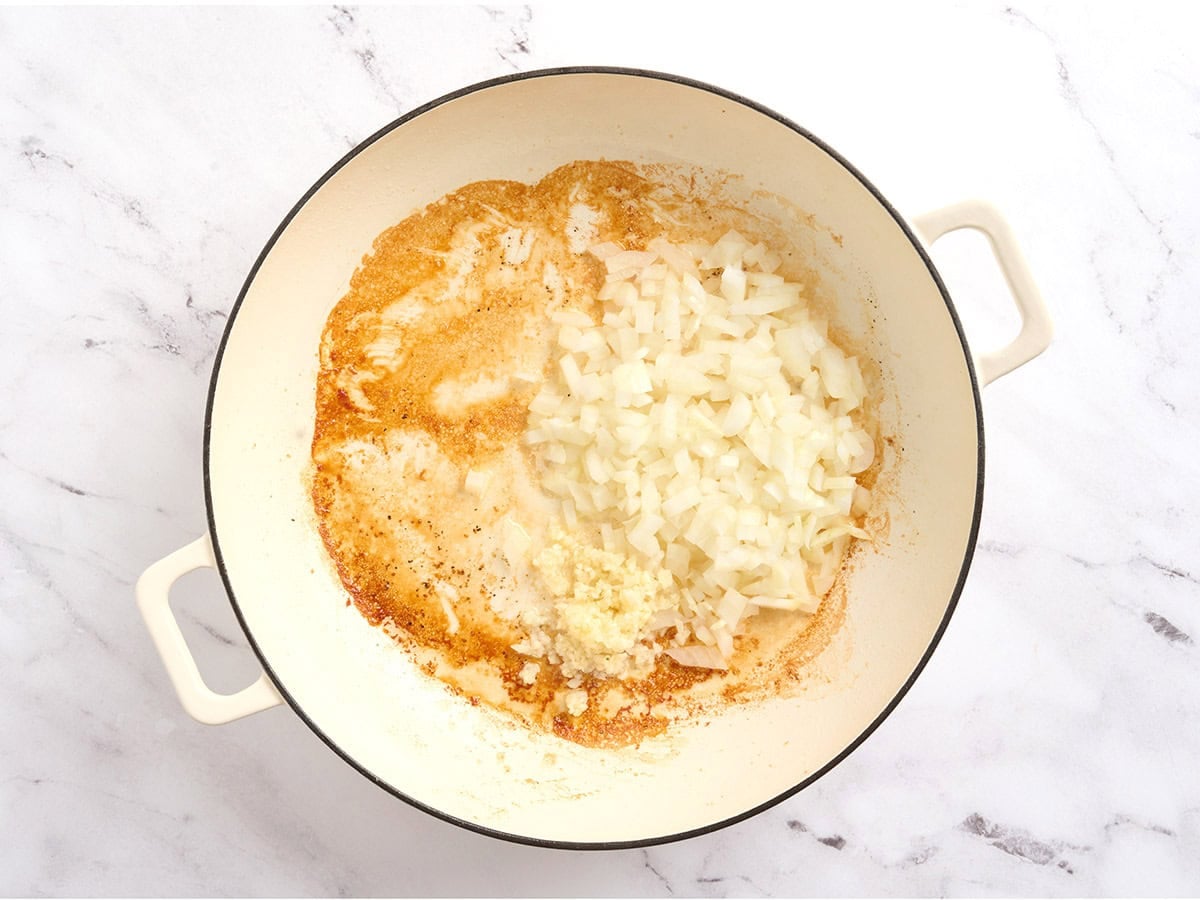 Onions and garlic sauteing in a skillet.