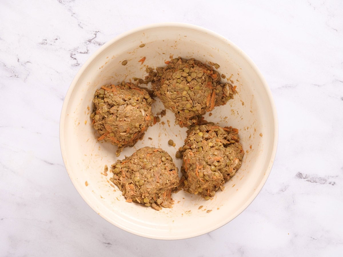 Lentil burger mixture formed into four balls in a bowl.