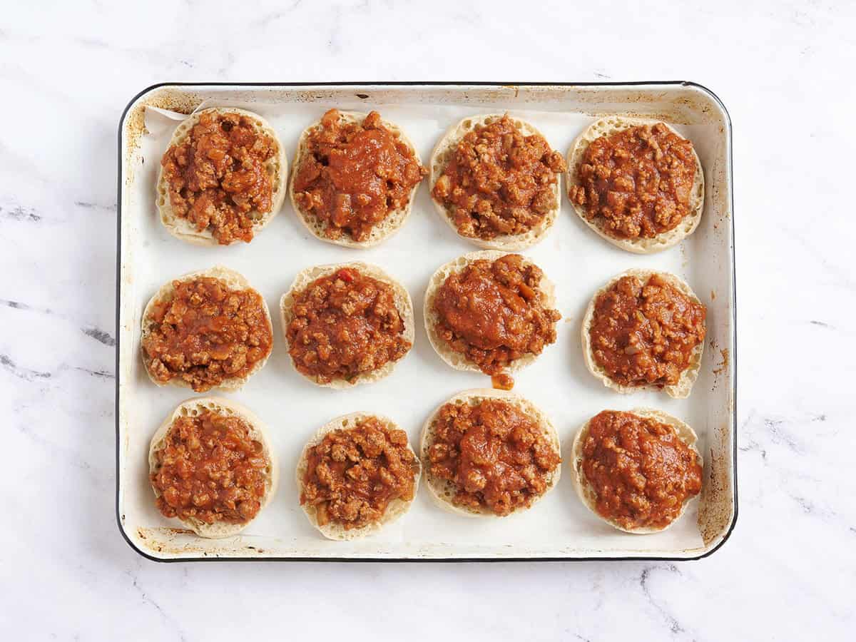 Meat sauce added to halved English muffin slices.