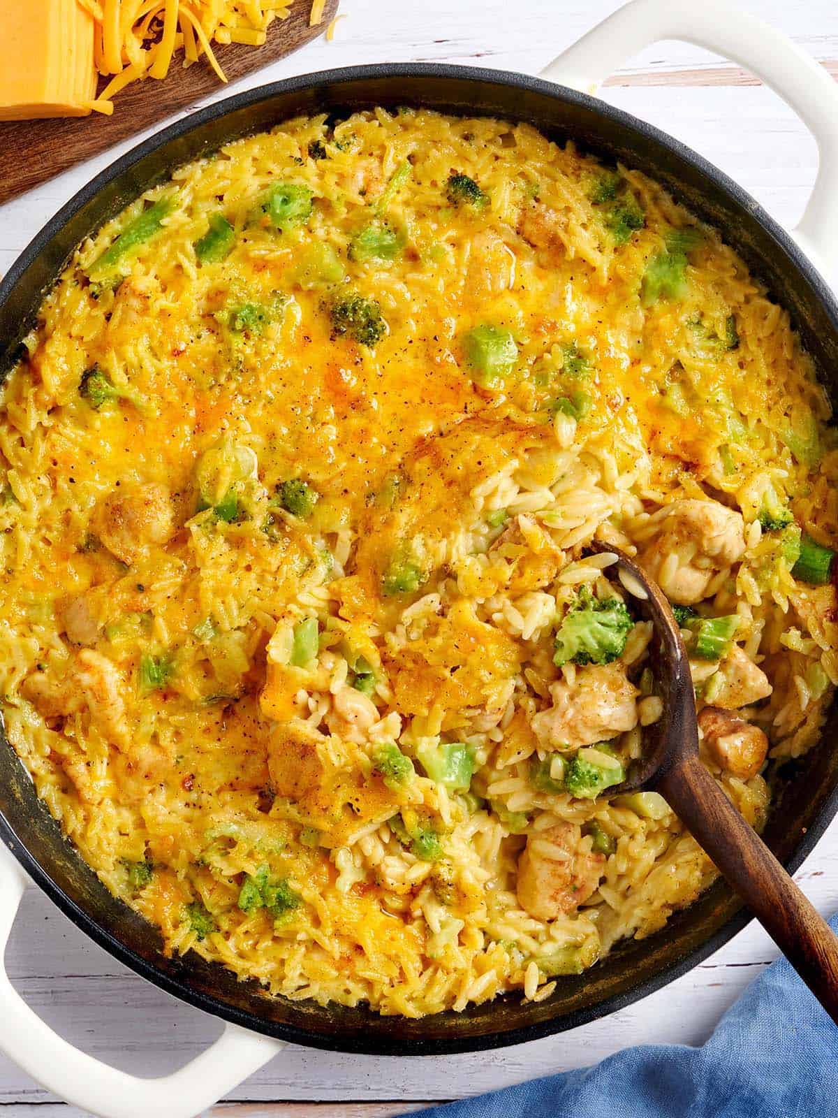 Overhead view of a chicken broccoli casserole with a wooden spoon.