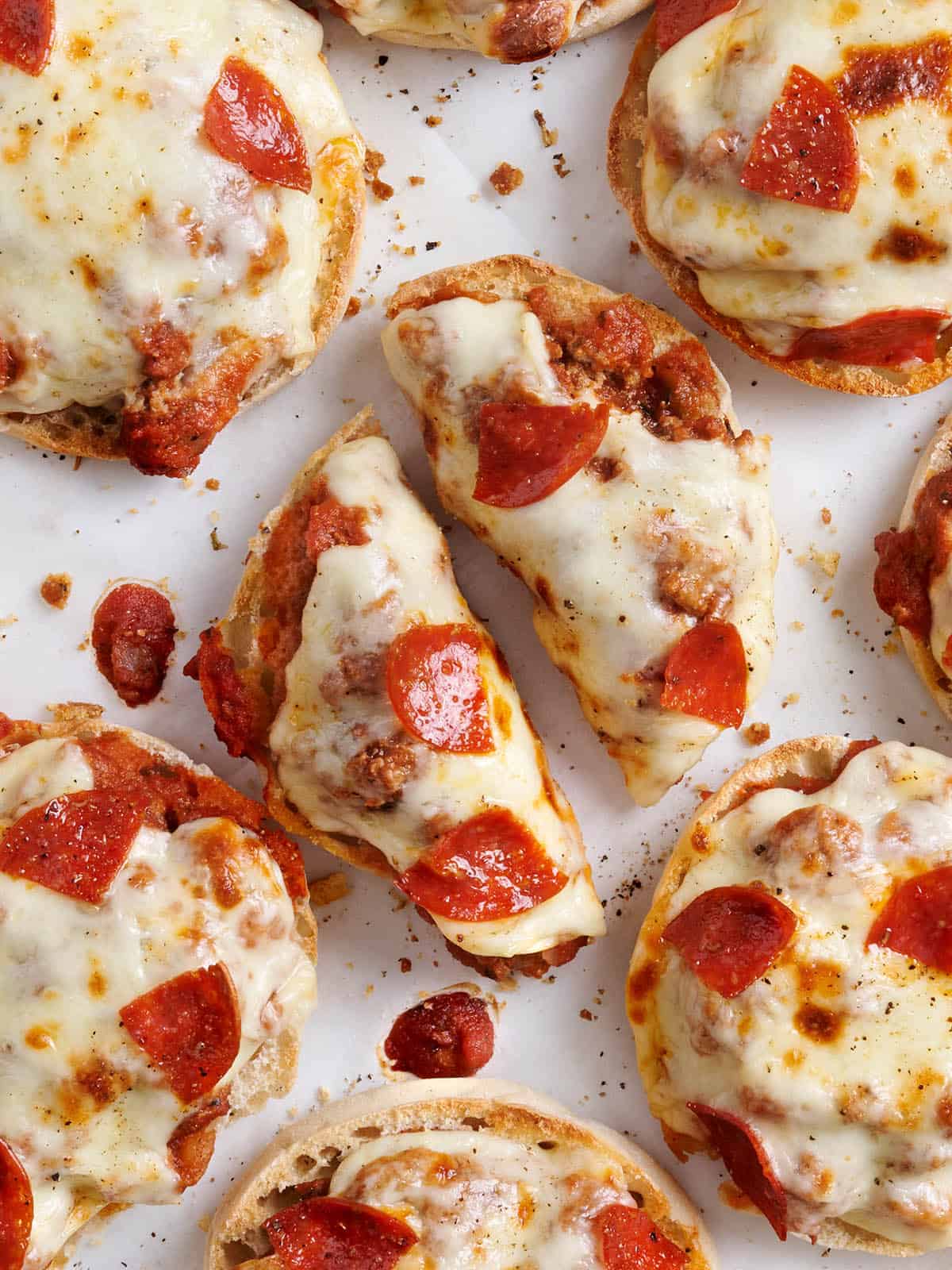Overhead view of homemade pizza burgers, with one cut in half.
