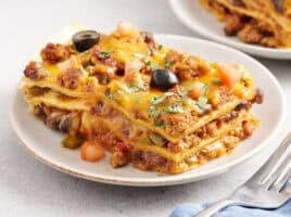 Sided view of a slice of taco casserole on a plate.