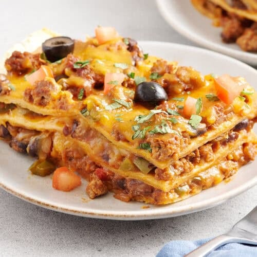Sided view of a slice of taco casserole on a plate.