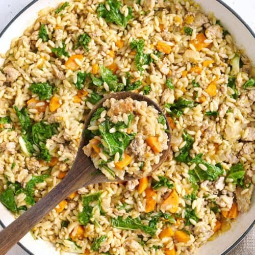 Overhead view of a sweet potato and ground turkey skillet with a wooden spoon.