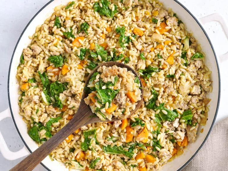 Overhead view of a sweet potato and ground turkey skillet with a wooden spoon.