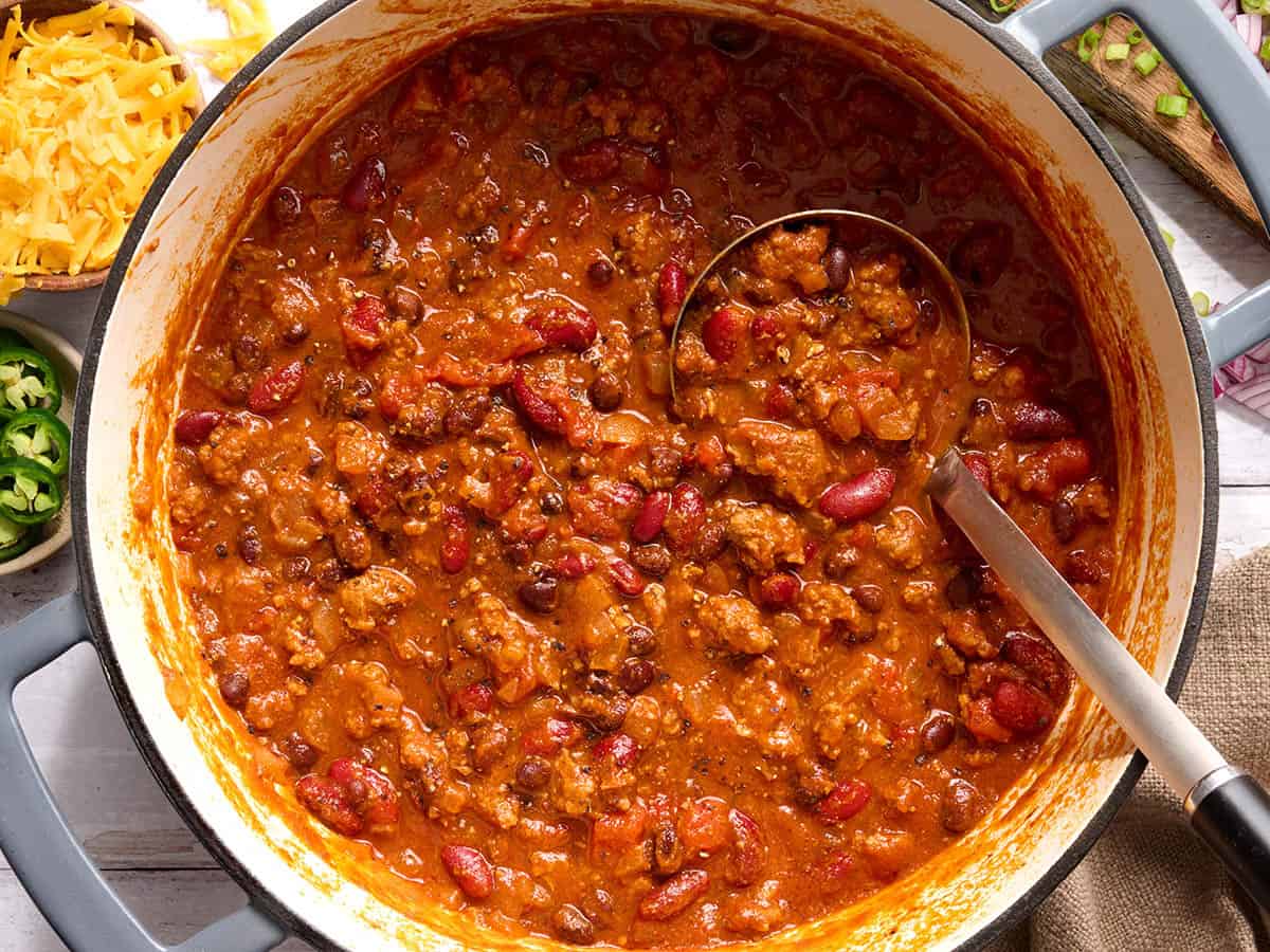 Overhead view of a pot of chili with a spoon.