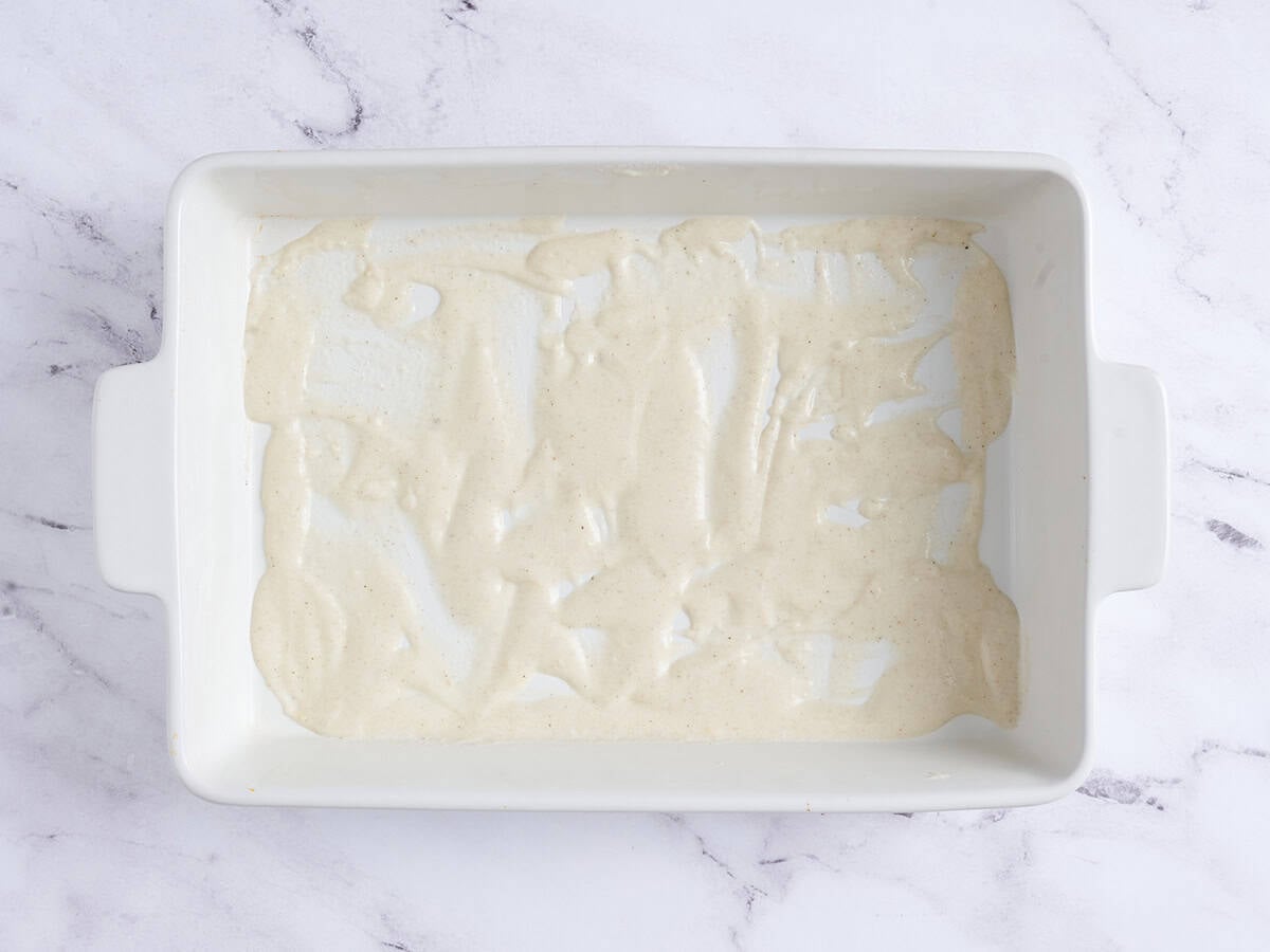 Bechamel sauce spread in a baking dish.