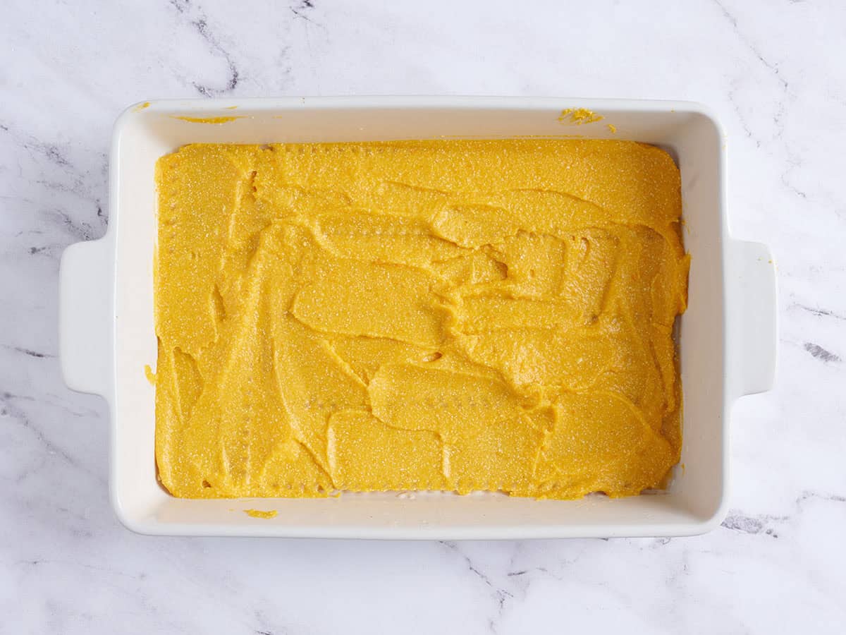 Butternut squash puree added to a baking dish to make a butternut squash lasagna.