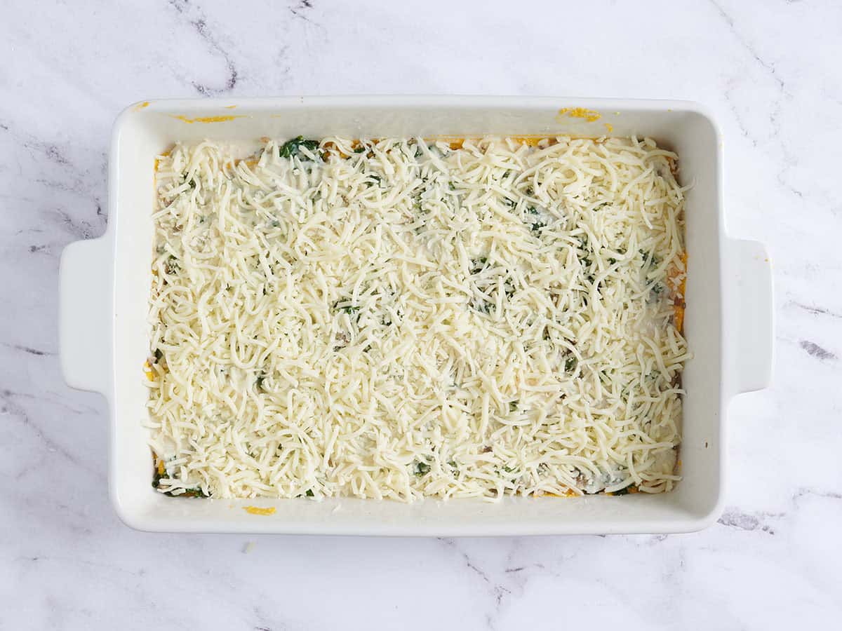 A homemade butternut squash lasagna topped with shredded cheese.