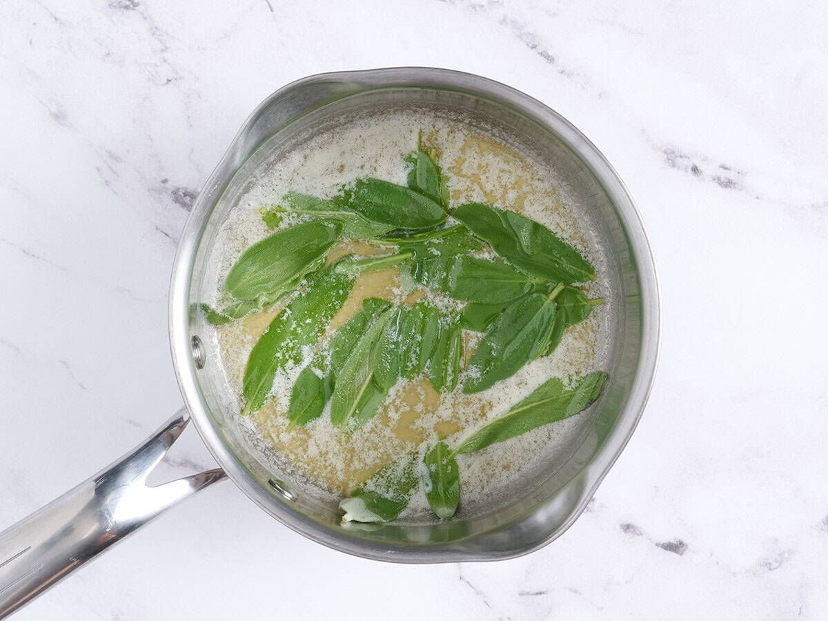Melted butter in a saucepan with sage leaves.